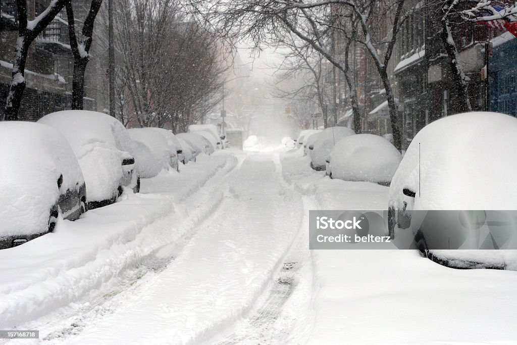 Looking down a road full of snow covered cars  Thompson st between Houston and prince in Soho Manhattan during the 2006 blizzard in New York City Snow Stock Photo