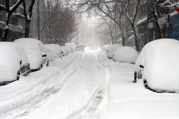 Looking down a road full of snow covered cars  stock photo