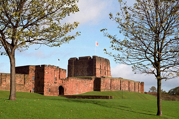 Exterior view of Carlisle Castle with green grass and sky stock photo