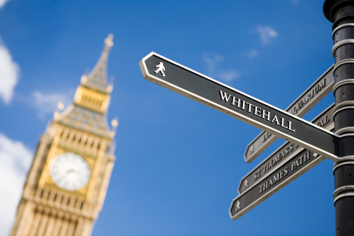 London señales que indican hacia Whitehall con Big Ben en el fondo photo