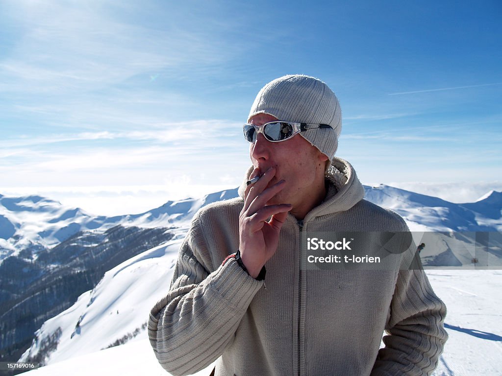 Smoking on top of the world young man contemplating intensely. Men Stock Photo