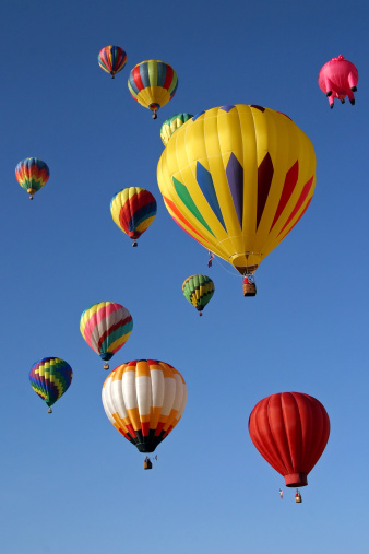 Many colorful hot air balloons in the sky.