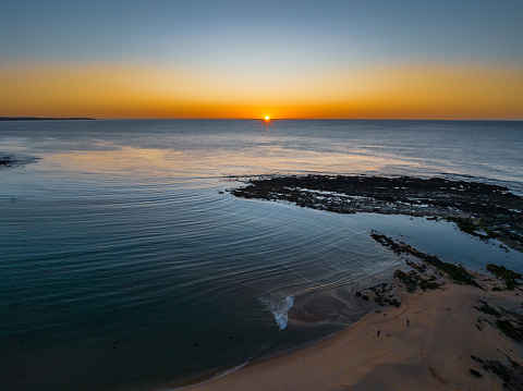 Sunrise over the ocean with a clear sky at Toowoon Bay on the Central Coast of NSW, Australia.