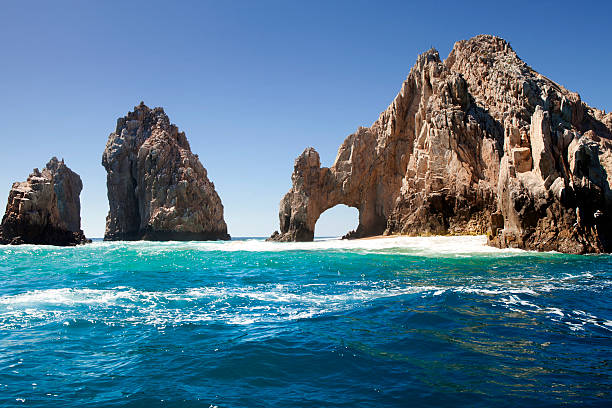 Unique jagged arch at Lands End in Cabo San Lucas Mexico The famous natural arch at Lands End in Cabo San Lucas, Mexico. baja california peninsula stock pictures, royalty-free photos & images
