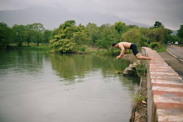 istock Man diving in the road side water body 1571724483