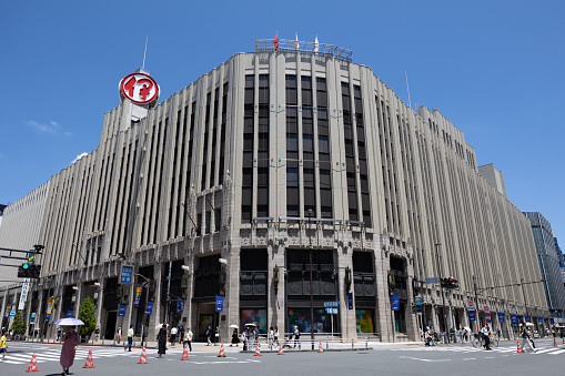 Tokyo, Japan - July 2, 2023 : Pedestrians walk past the Isetan department store in Tokyo, Japan.