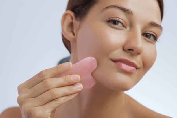 crop of woman beauty and skincare photo with self face massage gua sha tool - spooning fotografías e imágenes de stock