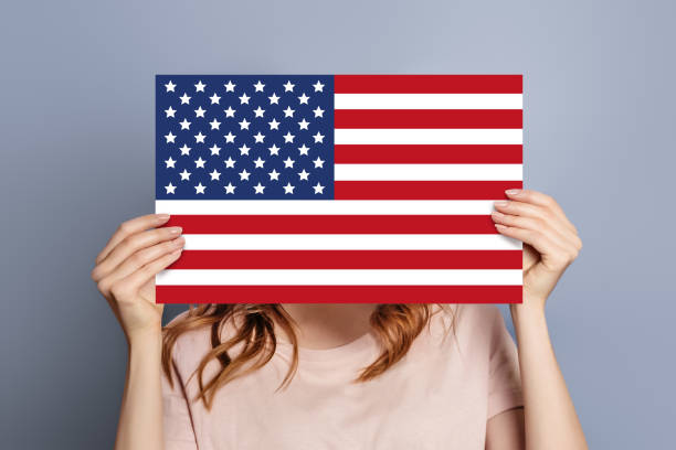 istock woman holds blank white speech bubble with American flag 1571766993