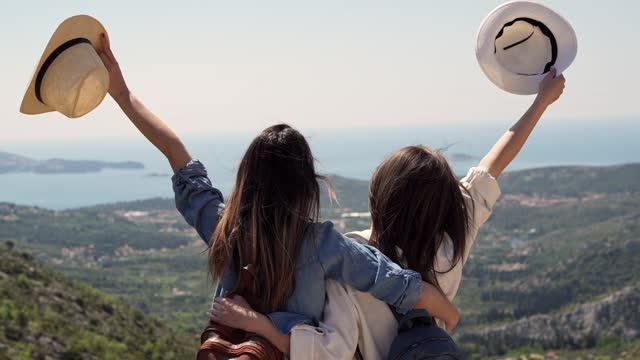 Two Female Friends Enjoying The View From A High Viewpoint In Croatia