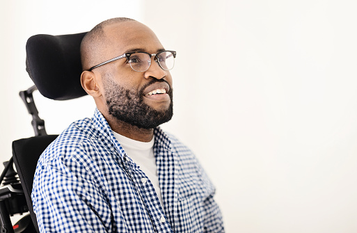 Portrait of a handicap black adult man with shaved head and glasses