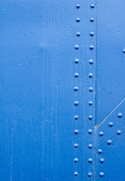 Blue Rivet Grunge Background Detail of a riveted section of an old metal bridge. riveted metal texture stock pictures, royalty-free photos & images