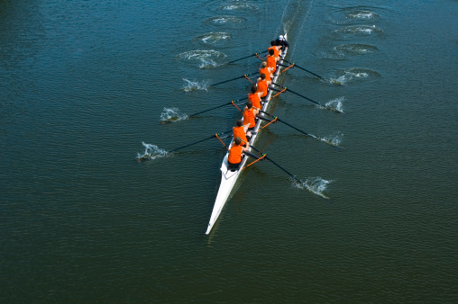 Full overhead image of an eight oar rowing crew in the open water. This is teamwork at its best.