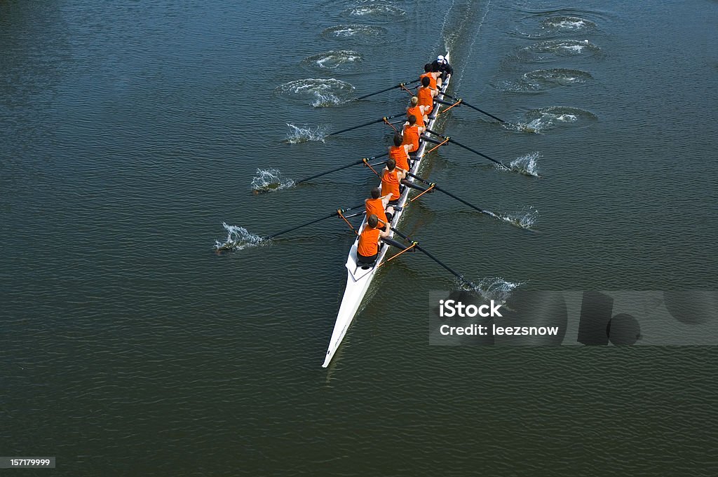 Eight Man Rowing Team - Teamwork Full overhead image of an eight oar rowing crew in the open water. This is teamwork at its best. Sport Rowing Stock Photo