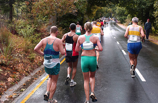 Several runners on a marathon running on a paved road
