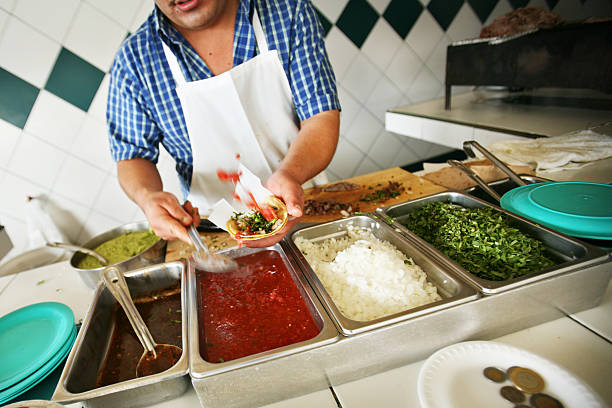 Worker Making Tacos at a Restaurant stock photo