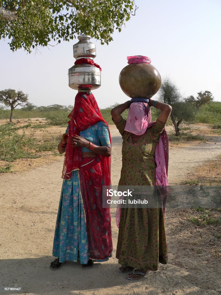 Belle femme indienne transport du village d'eau dans le désert - Photo de Eau libre de droits