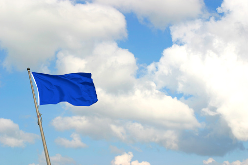Ukrainian and German flag develops against the sky. Conflict in Ukraine