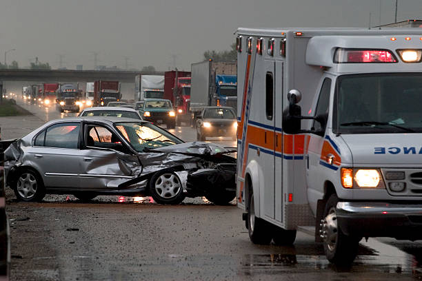 Car  Accident  Crash Car crash on major highway during rainfall at night. Ambulance in foreground and police car in background. crash stock pictures, royalty-free photos & images