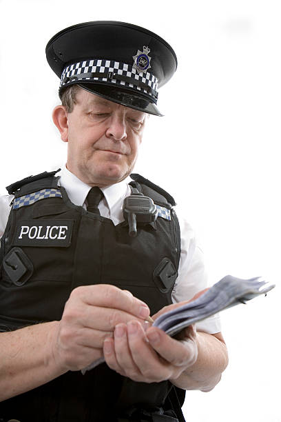 UK policeman: a uniformed officer taking notes from a case A UK police officer takes notes of an incident or writes out a parking ticket. metropolitan police stock pictures, royalty-free photos & images