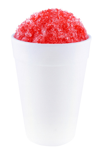 A cherry snow cone in a foam cup.