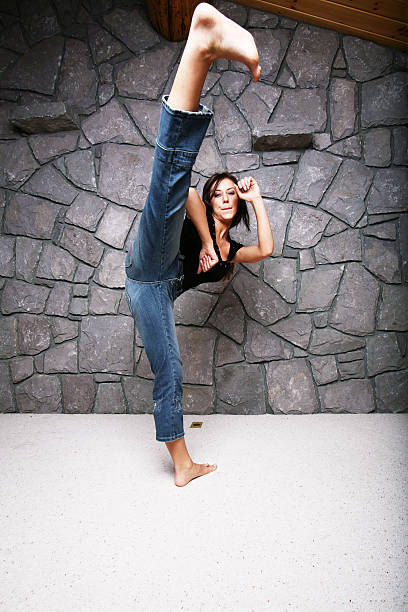 Młoda kobieta, ściskają sobie Karate Kick – zdjęcie