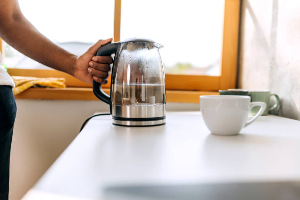 istock Close up shot of an unrecognisable man using kettle in kitchen 1571815654