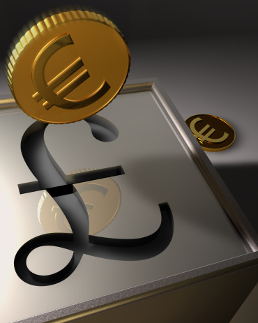 A 3D rendering of euros depicted as stylized golden colored coins entering a British Pound bank. The horizontal bar in the British Pound symbol doubles as the slot to the sterling colored box-shaped bank or safe box. The falling coin is aligned to drop into this slot. In the background is another euro-coin that can be seen as not yet deposited into the bank or as one coin that missed the slot and bounced off. The notion of converting currency is also impied.