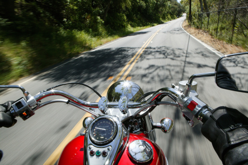 A vertical shot of a motorbike on the road with the beautiful view of mountains on Kauai, Hawaii