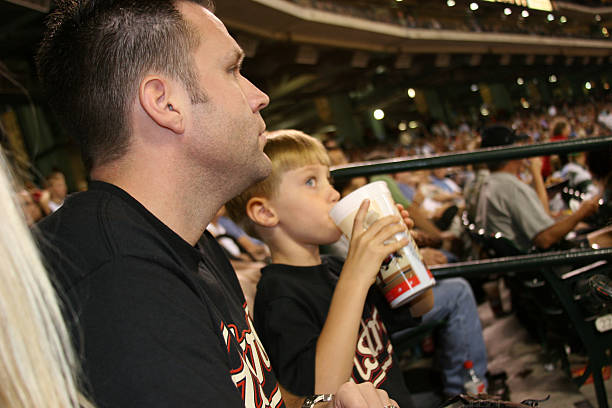 padre e figlio alla partita di baseball. stadio sportivo. da baseball. - baseball stadium fan sport foto e immagini stock