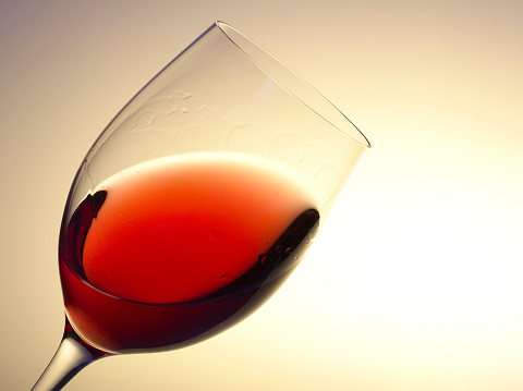 A pair of wine glasses in front of a purple background.