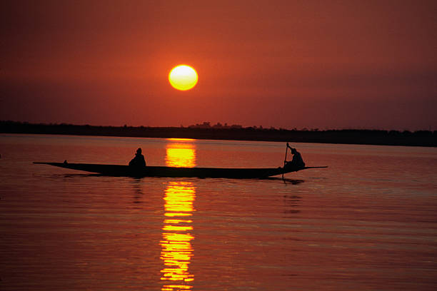 pôr do sol com canoa sobre o rio níger - niger river imagens e fotografias de stock