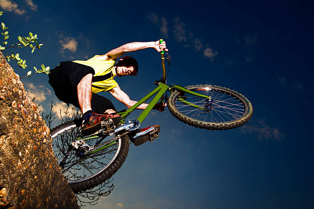 Extreme mountain biker jumping off a rock stock photo