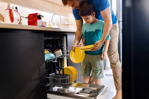 istock Father and son doing dishes together 1571825527