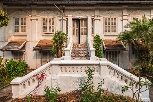 Traditional-style house with a white staircase in Luang Prabang, Laos. Historical colonial French architecture.