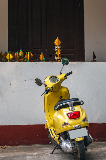 Yellow motorcycle parking in front of old wooden house.