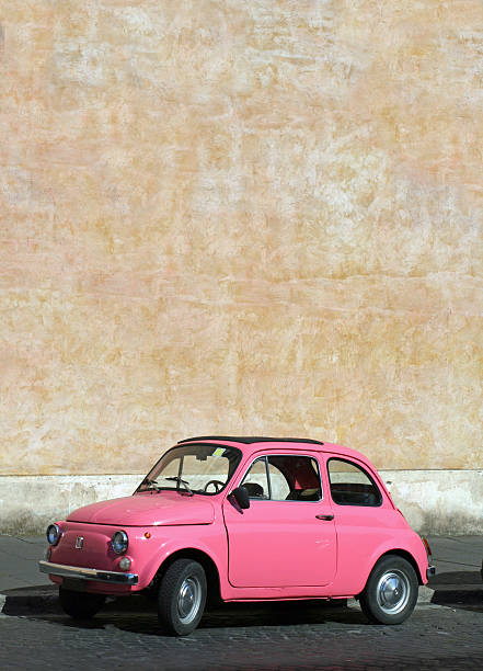 Small pink vintage Fiat car in Rome, Italy Tiny pink vintage car in Rome, Italy fortified wall photos stock pictures, royalty-free photos & images