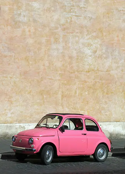 Photo of Small pink vintage Fiat car in Rome, Italy