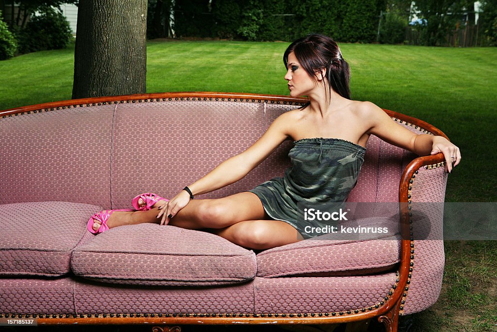 Joven mujer descansando en un sillón al aire libre - Foto de stock de A la moda libre de derechos