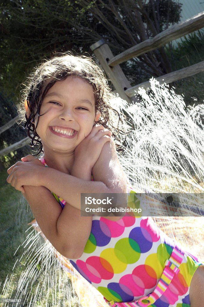 Girl スイムスーツを着ている楽しい夏のウォータースポーツ - 園芸用散水機のロイヤリティフリーストックフォト
