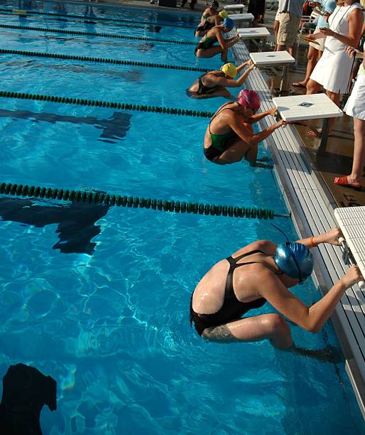 mujeres jóvenes nadadores en posición de inicio. - early teens child swimming pool swimming fotografías e imágenes de stock