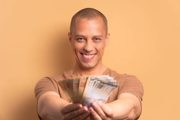 uomo gioioso che mostra i soldi, valuta brasiliana - real people enjoyment happiness confidence foto e immagini stock