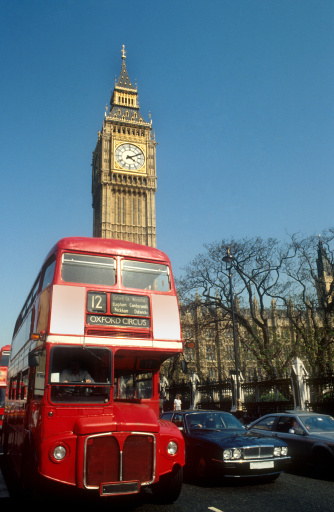 The classic London Routemaster red bus Big Ben and the Houses of Parliament  in the background