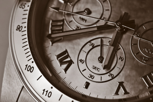 The partial face of a wrist watch - focus is on the hour hand.  Sepia toned.