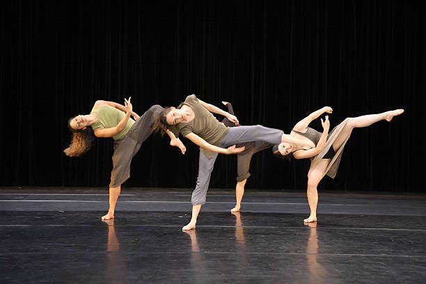 istock Four contemporary dancers kicking while performing on stage 157186441