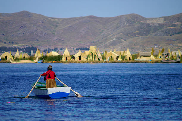 person paddling on a small boat at uros islands - 玻利維亞 個照片及圖片檔