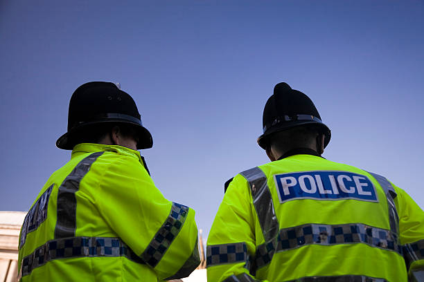 zwei britisch-polizisten mit traditionellen helme – klicken sie unten für mehr. - allgemein fotos stock-fotos und bilder