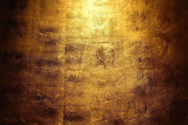 Light shining above a golden wall stock photo