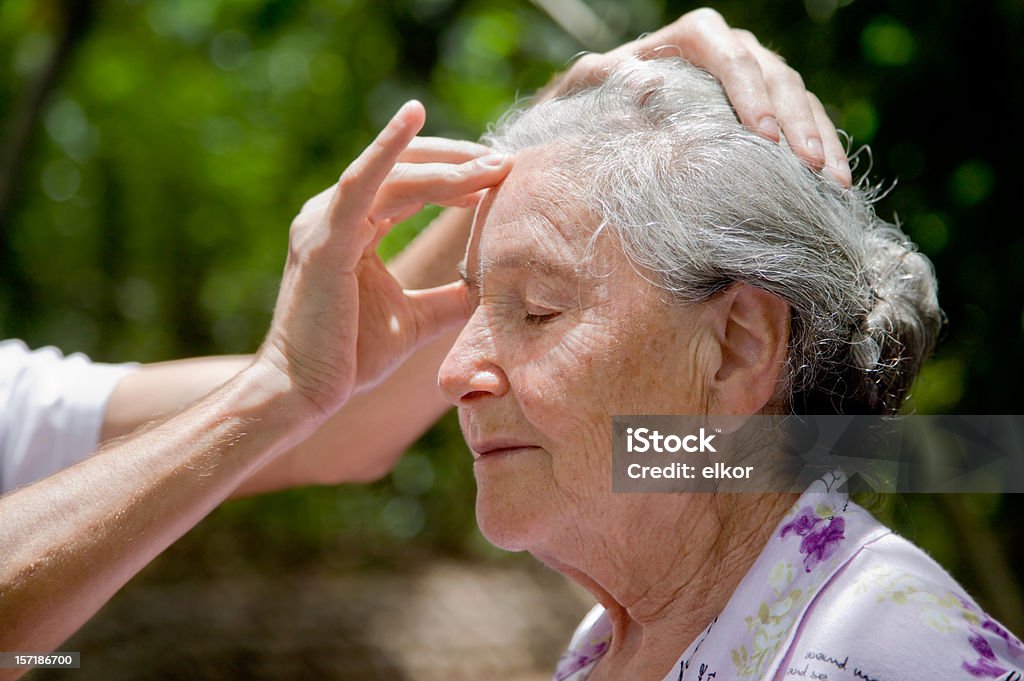 高齢者の女性屋外で受入ヘッドマッサージ - 1人のロイヤリティフリーストックフォト