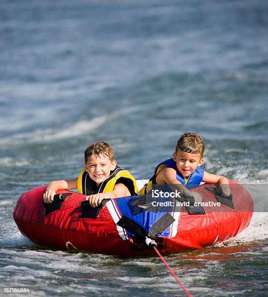 Giovani Ragazzi In Barca - Fotografie stock e altre immagini di Andare in barca a vela - Andare in barca a vela, Famiglia, Composizione verticale