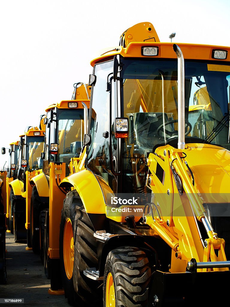 Diggers in a Row on Industrial Parking Lot  Construction Equipment Stock Photo